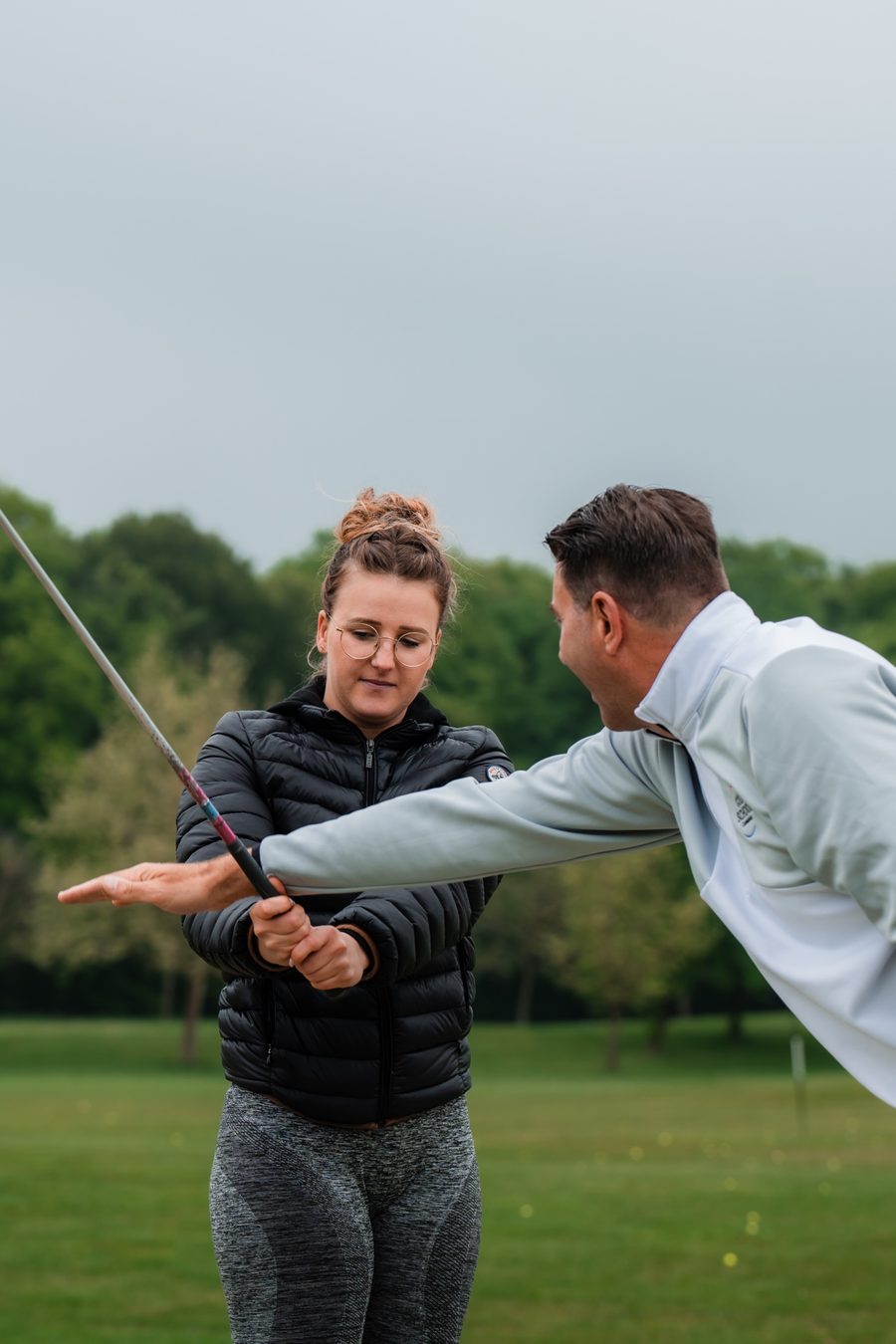 Coach giving a lesson to an adult golfer