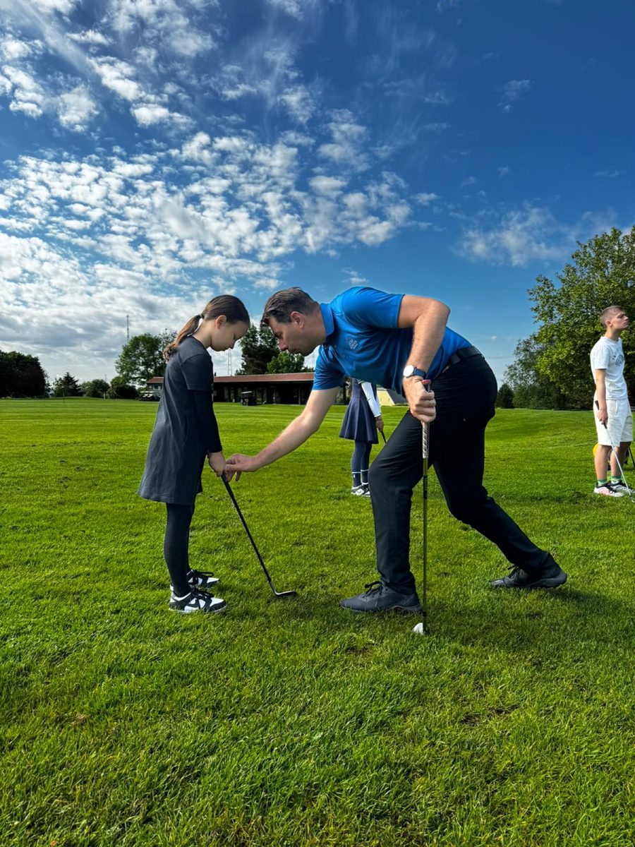 Coach helping a young girl with her set-up
