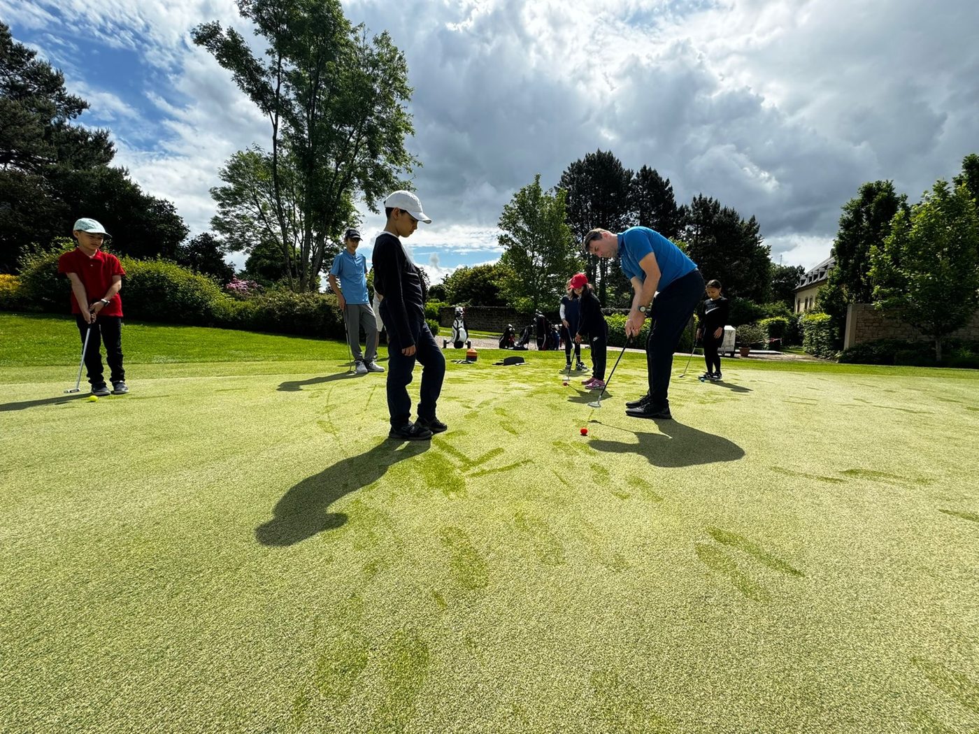 Junior group practising putting with their coaches