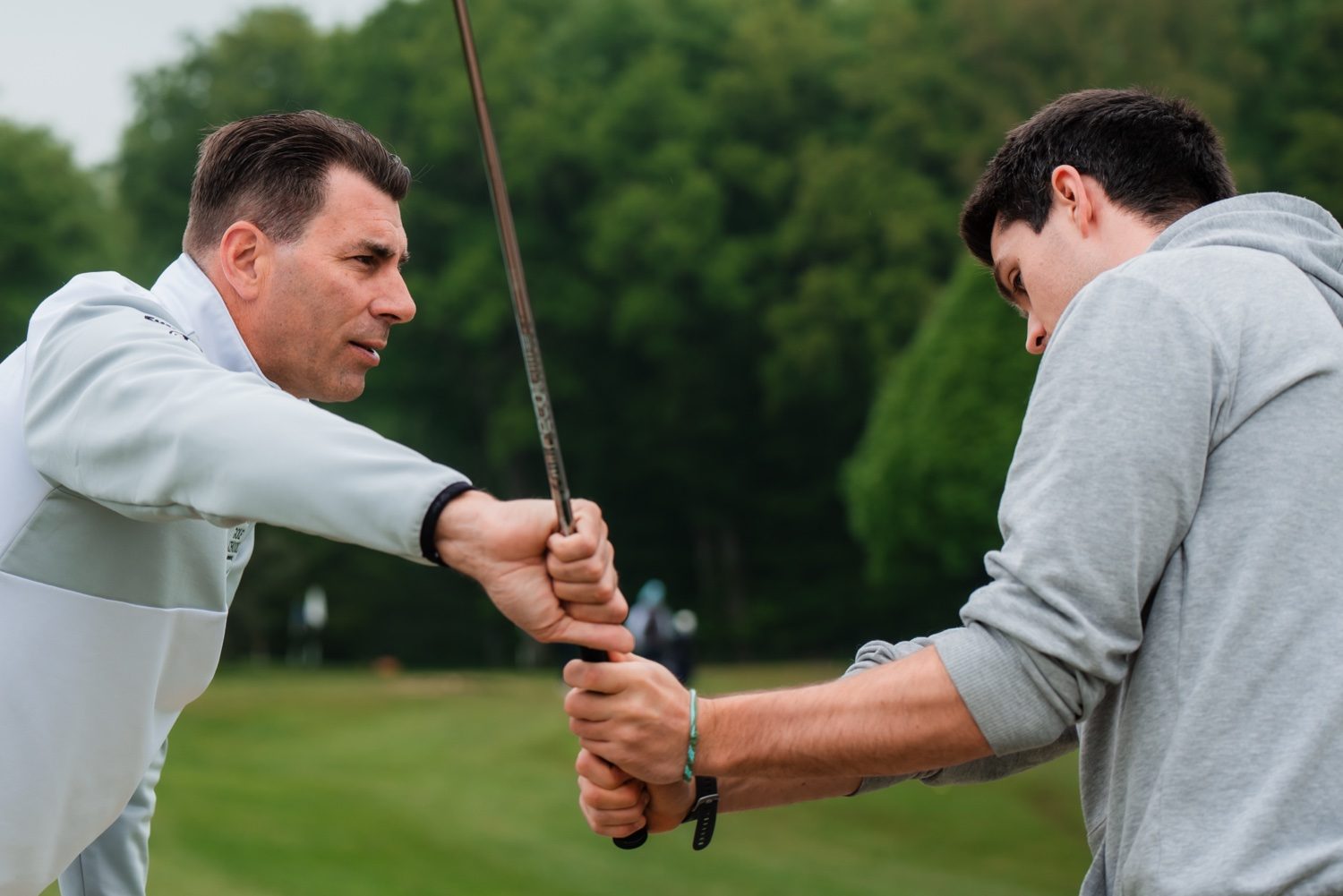 Coach adjusting a golfer's grip