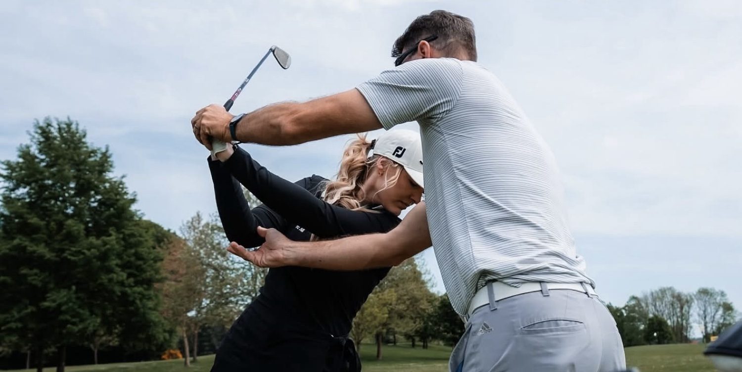 Coach guiding a golfer through her backswing